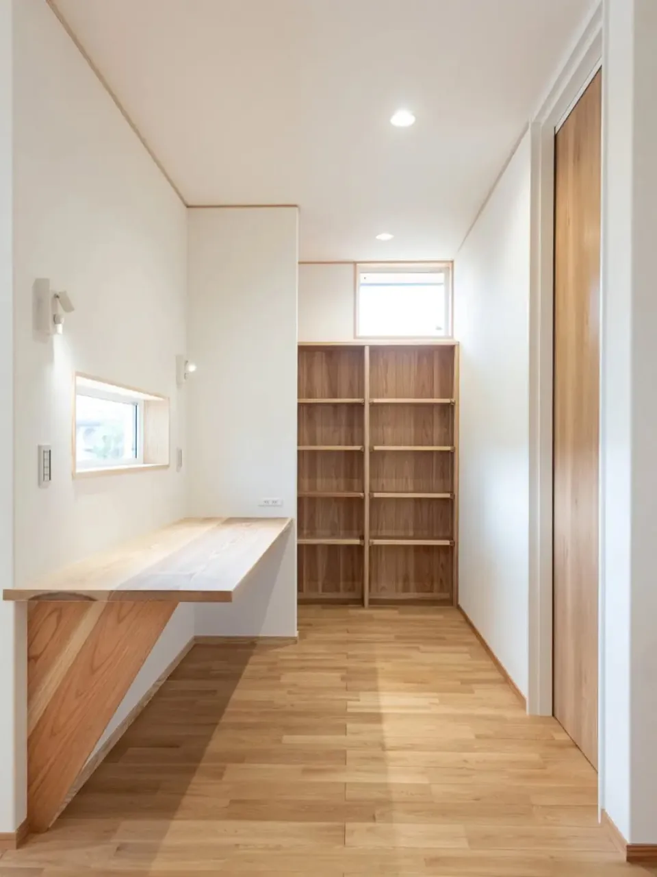 白い外壁に、木の玄関ドアがよく映える平屋。