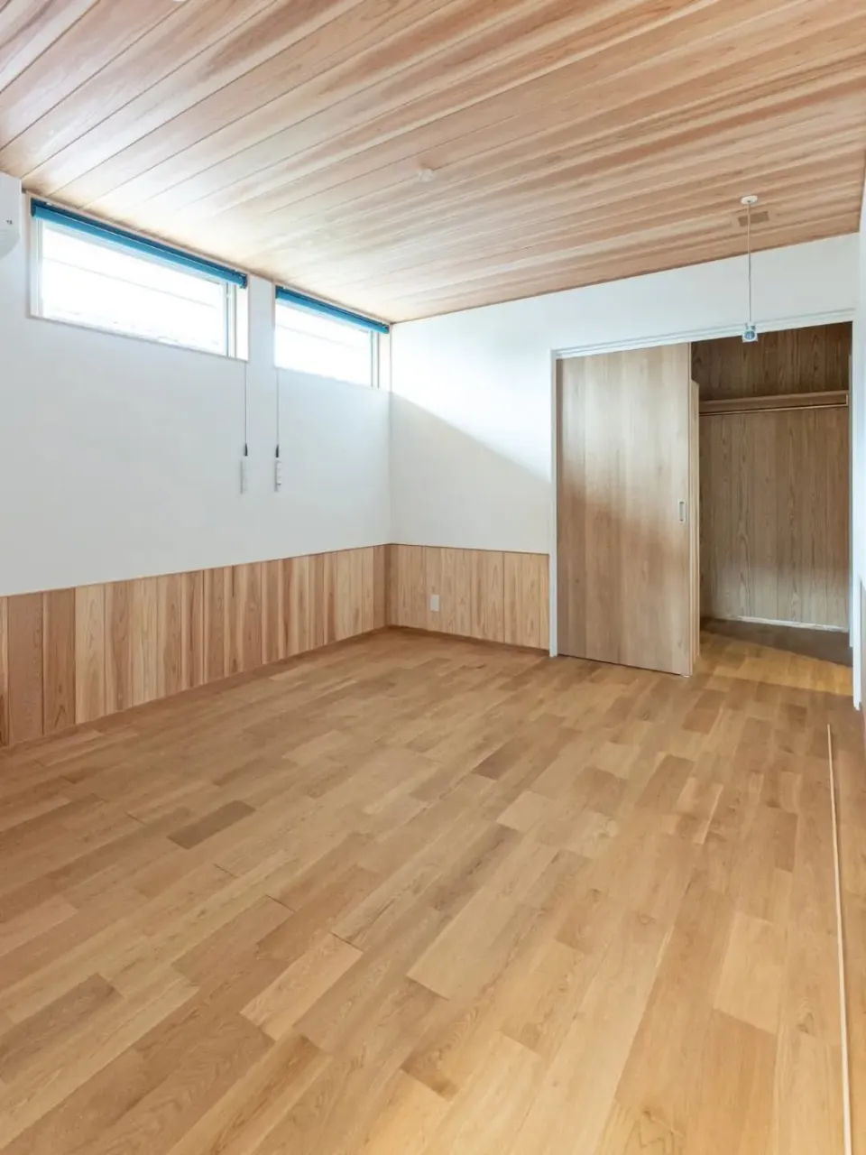 白い外壁に、木の玄関ドアがよく映える平屋。